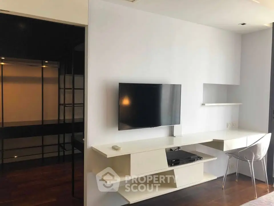 Modern living room with sleek TV setup and minimalist desk area