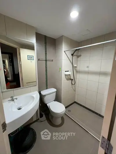Modern bathroom with walk-in shower and sleek fixtures in a contemporary apartment.