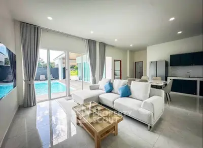 Spacious modern living room with pool view, open layout, and elegant furnishings.