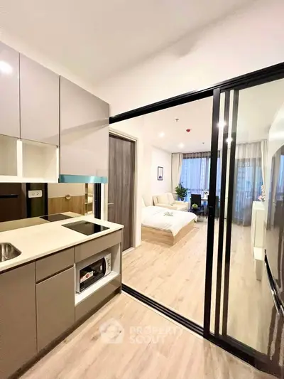 Modern studio apartment with sleek kitchen and cozy bedroom