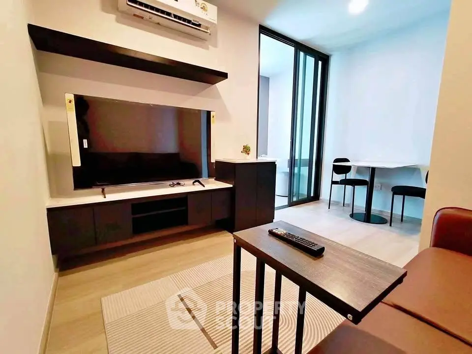 Modern living room with sleek furniture and large TV, featuring a cozy ambiance and stylish decor.