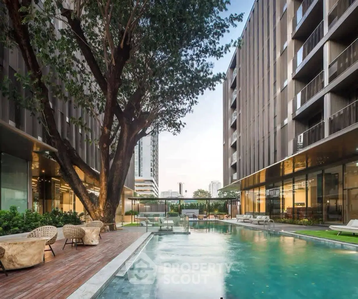 Luxurious modern apartment complex with stunning pool and lush greenery.