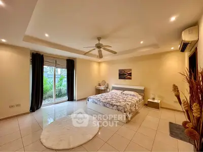 Spacious bedroom with modern decor and garden view, featuring elegant lighting and tiled flooring.