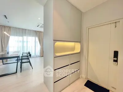 Modern interior with sleek storage and dining area, featuring natural light and elegant design.