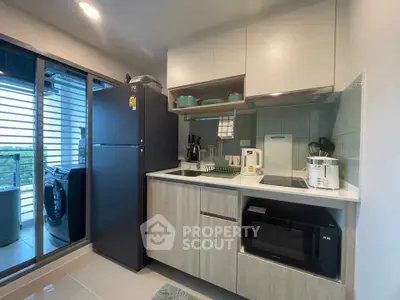 Modern kitchen with sleek appliances and balcony view in stylish apartment