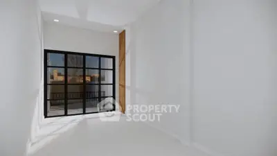 Spacious modern room with large window and city view, perfect for urban living.