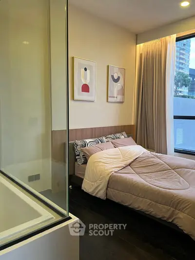 Modern bedroom with elegant decor and large window offering city view