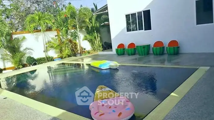 Luxurious private pool with tropical garden and stylish seating area.