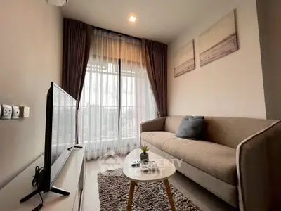 Cozy living room with modern decor and large window offering city views.