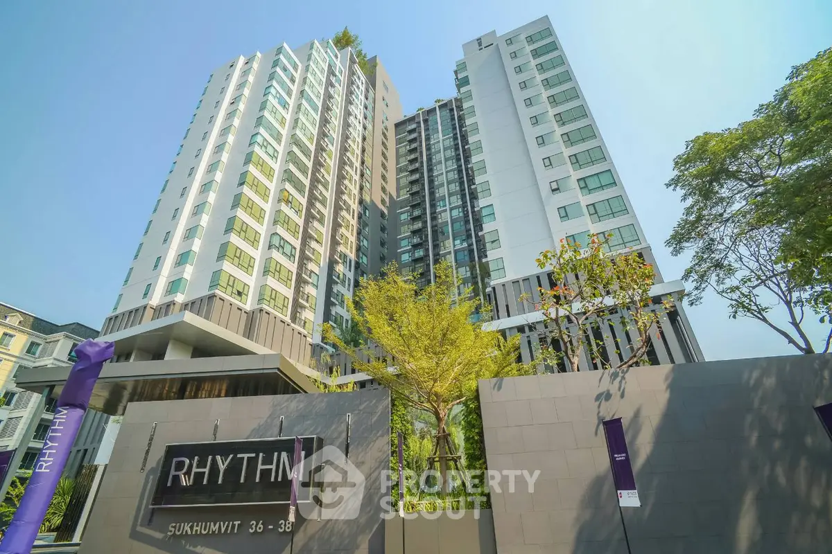 Modern high-rise condominium with sleek design and lush greenery at Rhythm Sukhumvit 36-38.