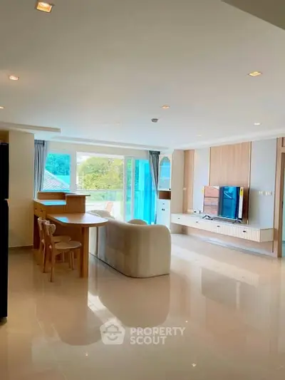 Spacious modern living room with sleek furniture and large windows offering natural light.