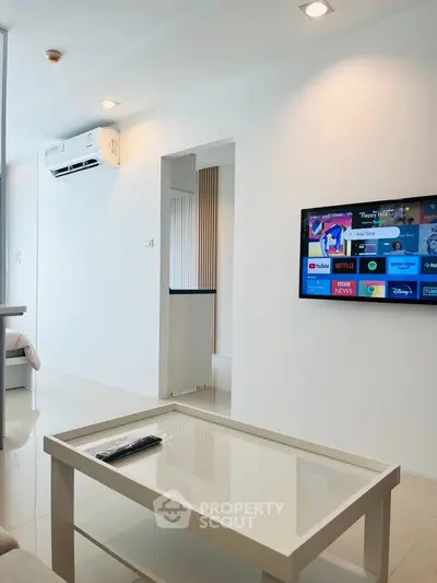 Modern living room with wall-mounted TV and sleek white furniture