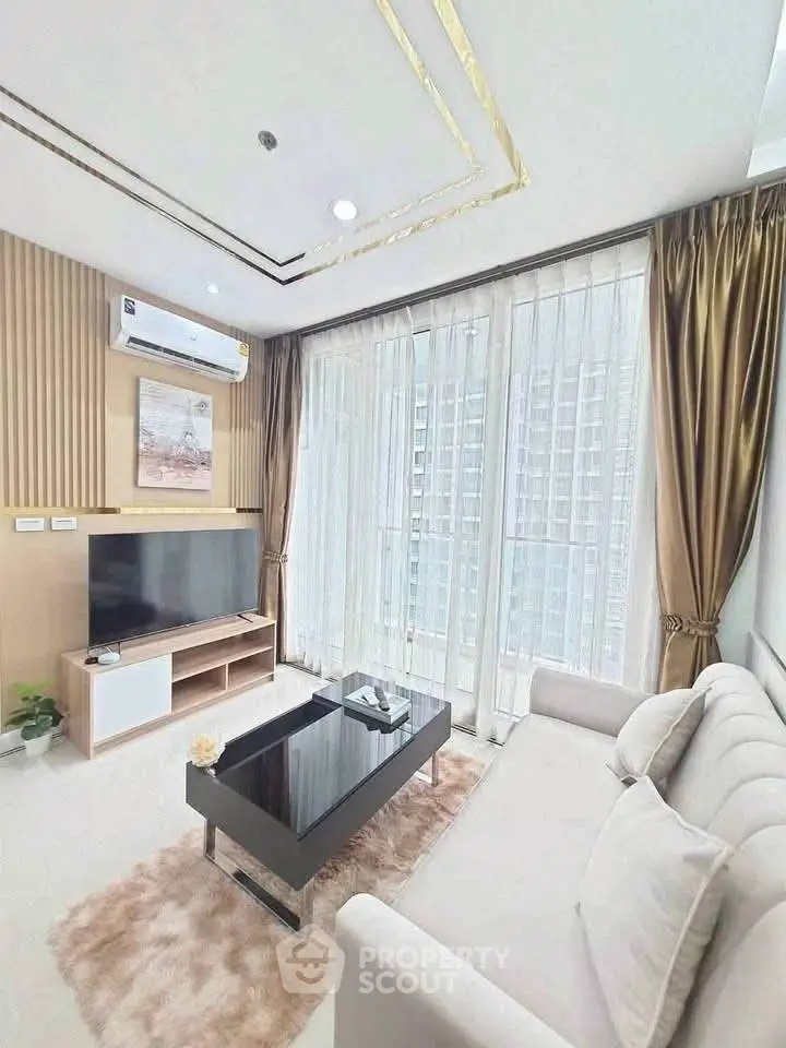 Modern living room with large windows and stylish decor in a high-rise apartment.