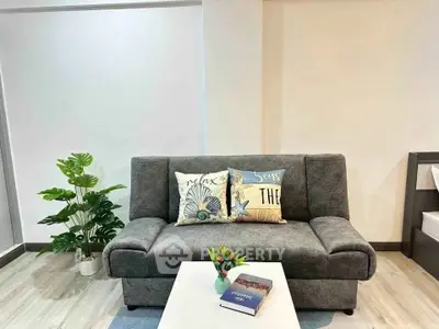 Cozy living room with stylish gray sofa and decorative pillows, perfect for relaxation.