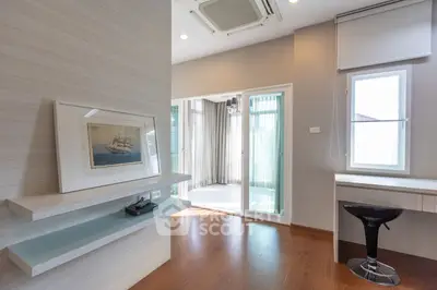 Spacious and well-lit living room with modern floating TV console, sleek flooring, and large windows leading to a sunny balcony.