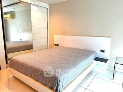 Modern bedroom with sleek design and large mirror closet doors.
