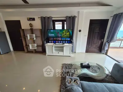 Spacious living room with modern decor and ocean view balcony access