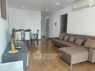 Spacious living room with modern furniture and wooden flooring, perfect for family gatherings.