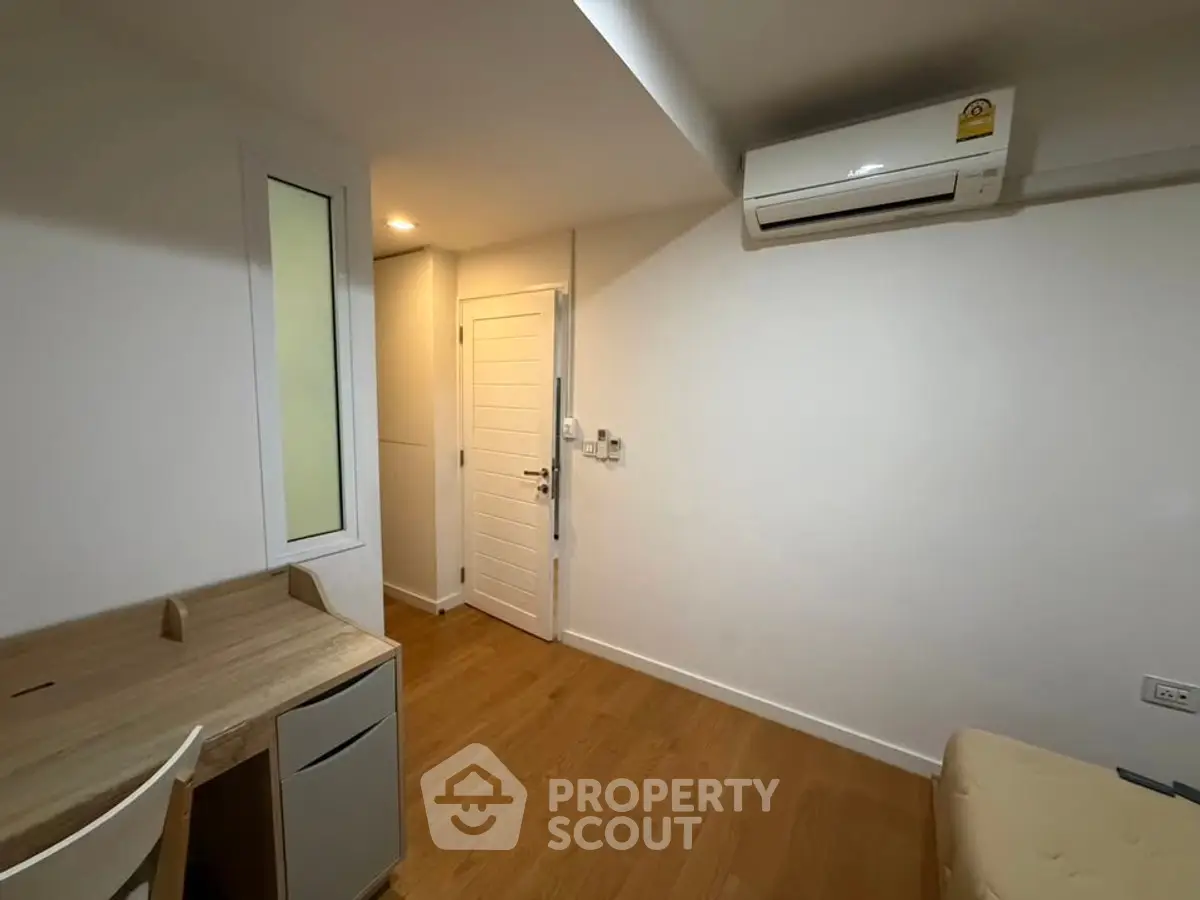 Cozy study room with wooden desk and air conditioning in modern apartment.