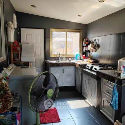 Charming kitchen with modern appliances and ample natural light, featuring a gas stove and stylish cabinetry.