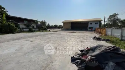 Expansive industrial property with large open concrete yard and warehouse building.