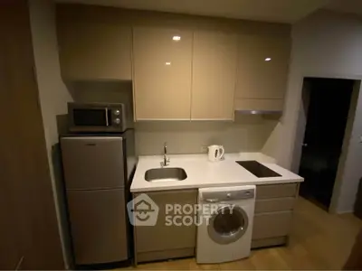 Modern compact kitchen with sleek cabinetry, integrated appliances, and efficient layout.