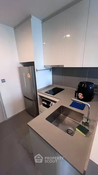 Modern compact kitchen with sleek cabinetry and built-in appliances