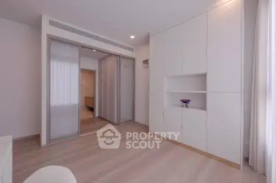 Spacious modern bedroom with sleek built-in storage and sliding closet doors.