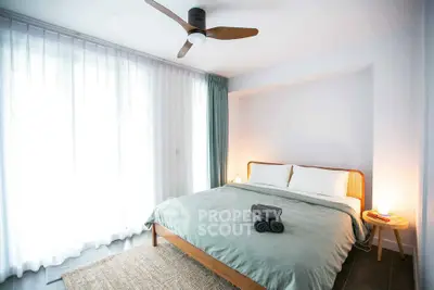 Bright and cozy bedroom with modern ceiling fan and soft lighting, perfect for relaxation.