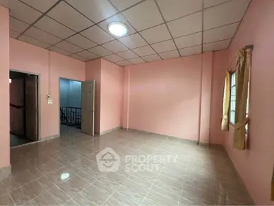 Spacious empty room with tiled flooring and pink walls, ideal for customization.