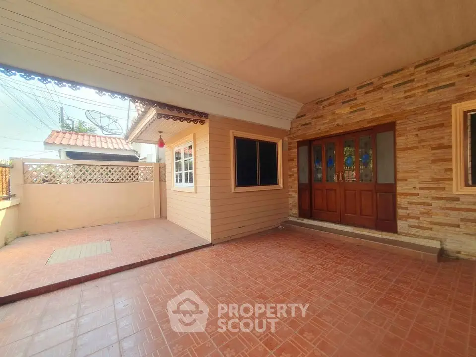 Charming house entrance with tiled patio and wooden door