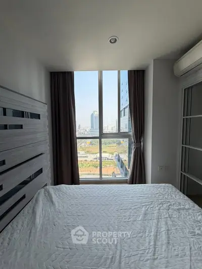 Modern bedroom with large window offering stunning city view