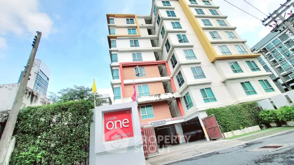 Modern condo building with vibrant facade and lush greenery in prime urban location.