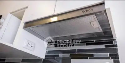 Modern kitchen with sleek range hood and stylish backsplash tiles.