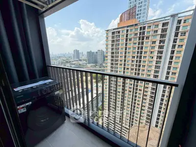 High-rise apartment balcony with stunning city view and washing machine.