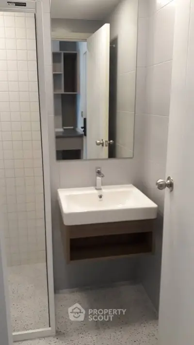 Modern bathroom with sleek sink and large mirror in a contemporary apartment.