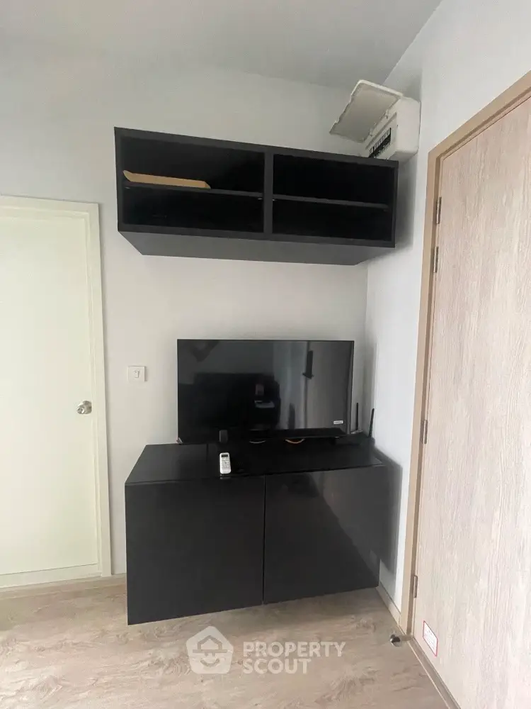 Modern living room with sleek black TV cabinet and wall-mounted storage