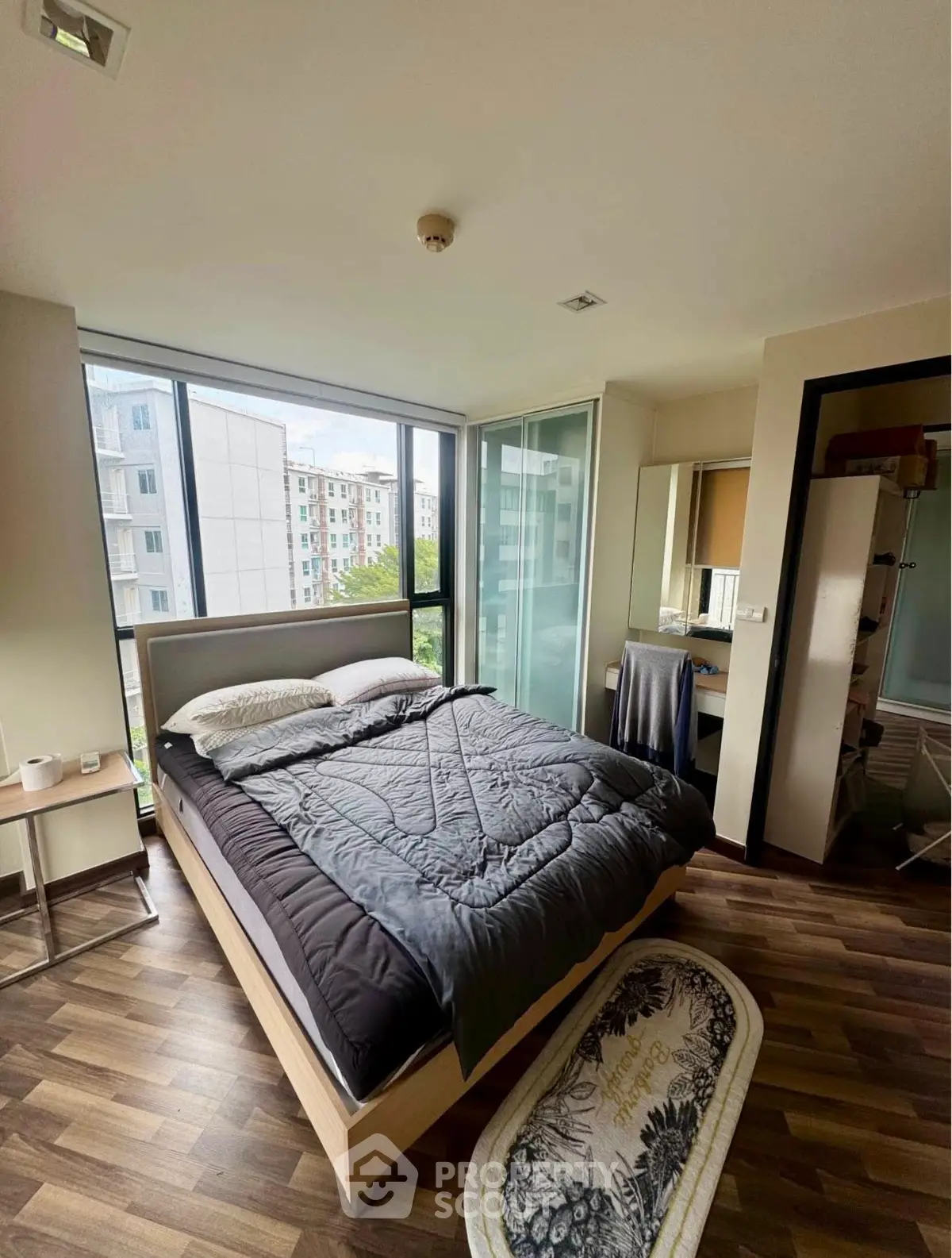 Modern bedroom with large windows and stylish decor in urban apartment