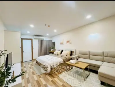 Modern and cozy bedroom with stylish decor and comfortable seating area.