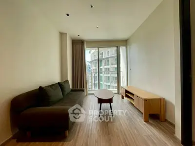 Modern living room with sleek furniture and large windows offering a city view.