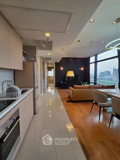 Luxurious open-plan living room with modern kitchen and stunning city view.