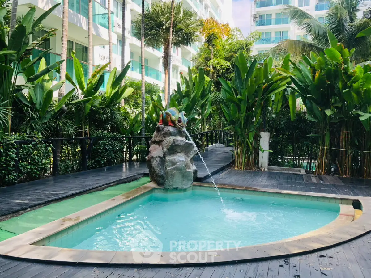 Luxurious condominium pool area with lush greenery and modern design.