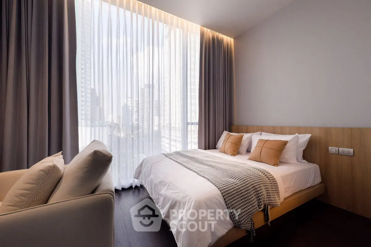 Luxurious bedroom with floor-to-ceiling windows and elegant decor in a modern apartment.