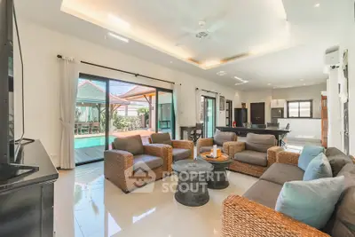 Spacious living room with pool view and modern open kitchen layout