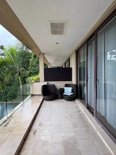 Luxurious balcony with elegant seating and lush greenery view