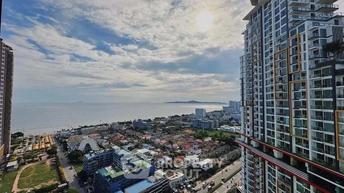 Stunning ocean view from high-rise apartment overlooking cityscape and coastline.