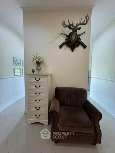 Charming interior with elegant armchair and decorative wall mount in cozy living space.