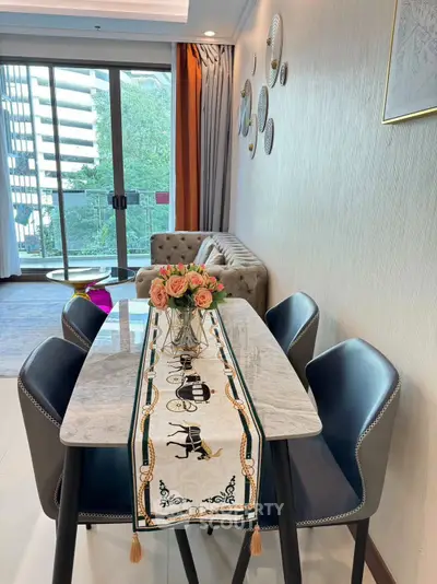 Elegant living room with modern dining area and large windows offering natural light.