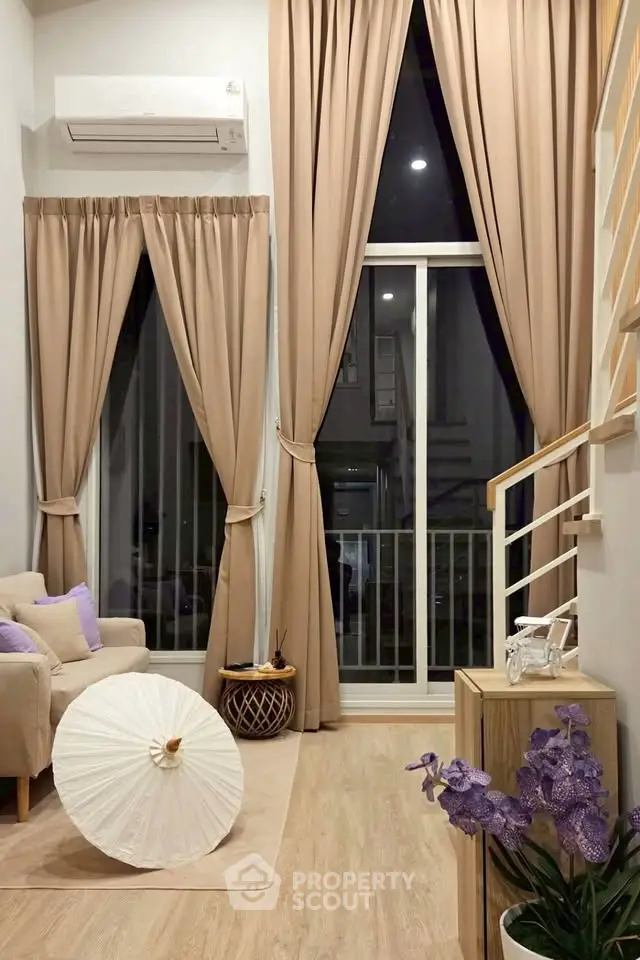 Elegant living room with high ceilings, large windows, and stylish decor in a modern apartment.