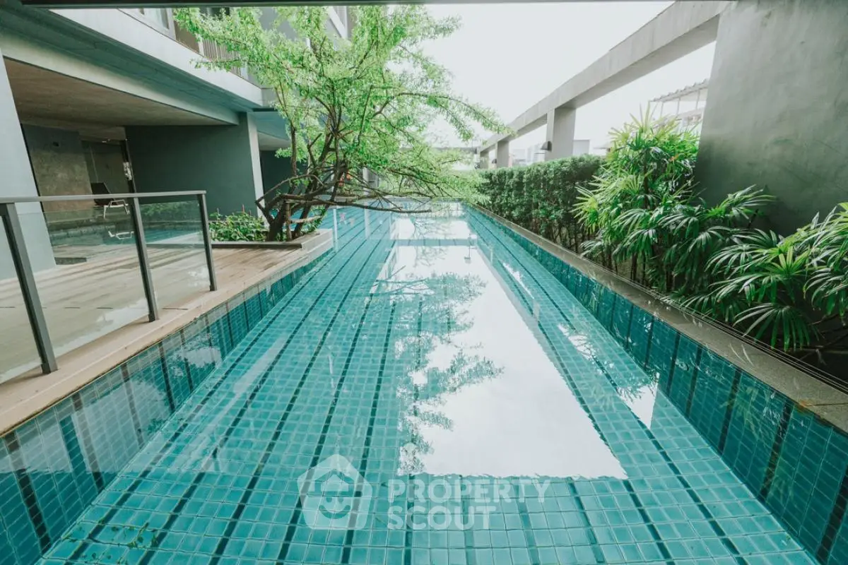 Luxurious modern swimming pool with lush greenery in upscale residential complex